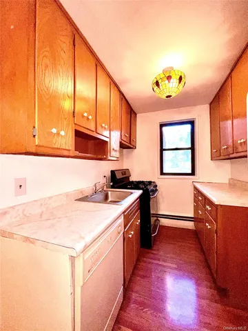 a kitchen with a stove a sink and a window