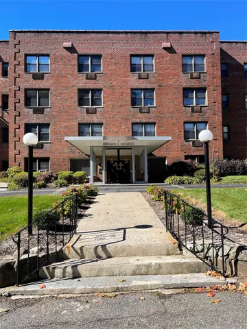 a view of a brick building next to a yard