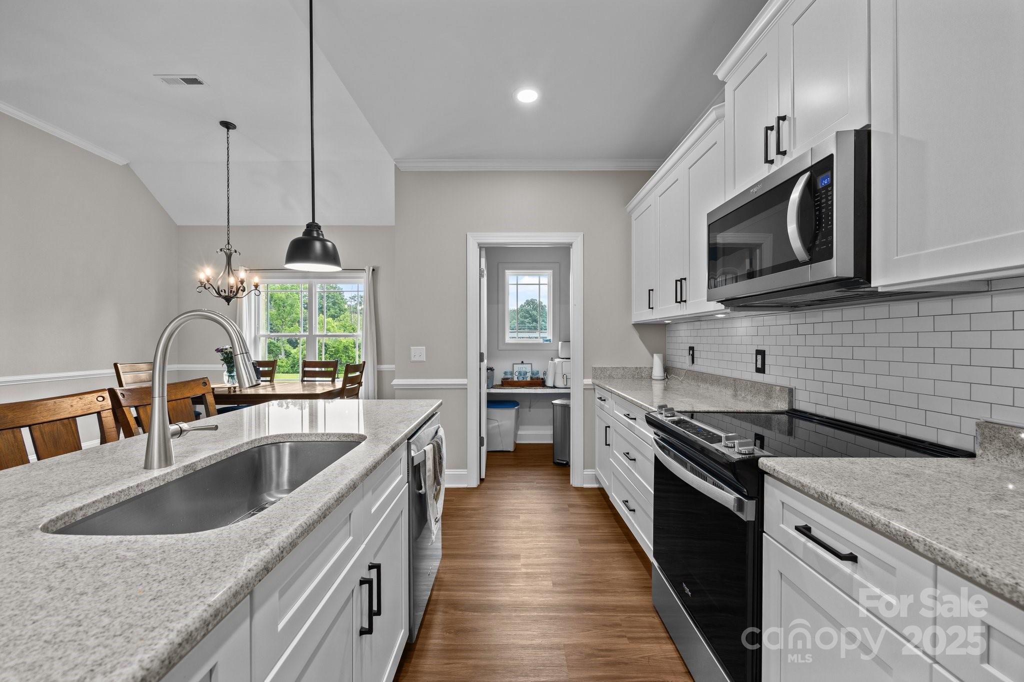 3855 East Holly Grove Road Lexington, NC 27292 - Photo 12 of 42 a kitchen with stainless steel appliances granite countertop a sink a stove and a wooden floors