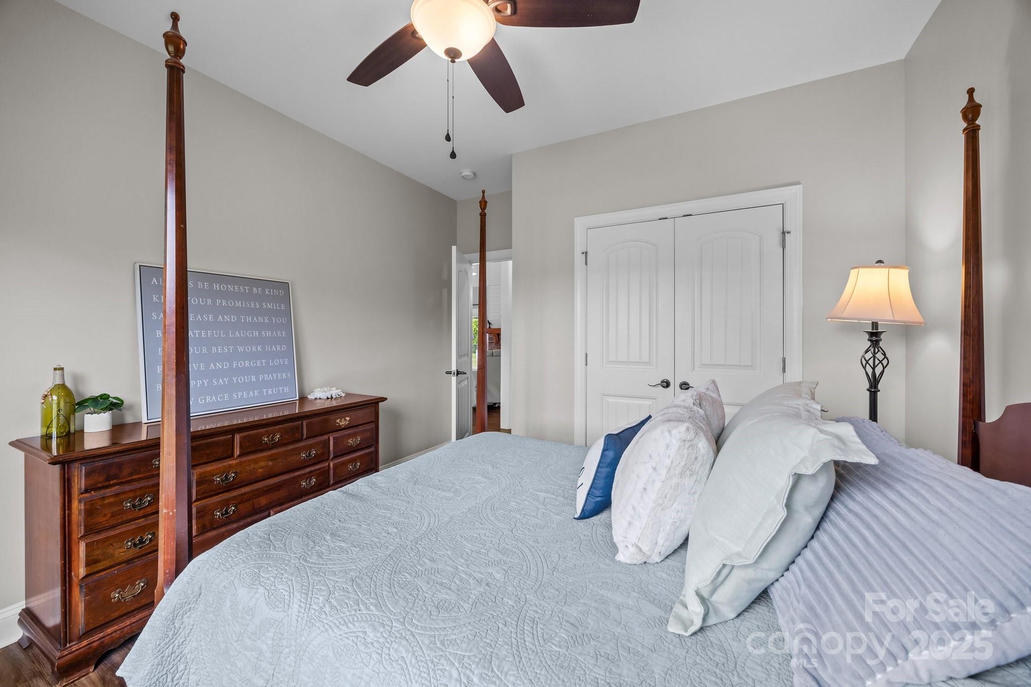 3855 East Holly Grove Road Lexington, NC 27292 - Photo 19 of 42 a bedroom with a bed and a chandelier
