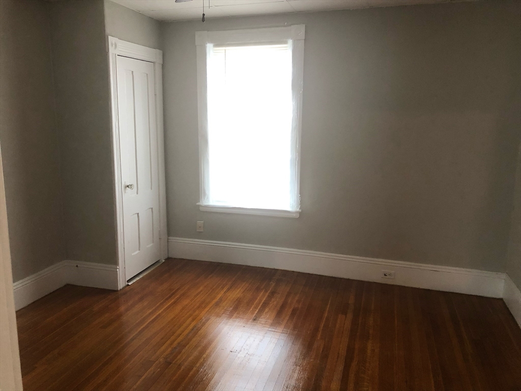 21 Whipple Street, Unit 3 Worcester, MA 01607 - Photo 8 of 8 an empty room with wooden floor and windows