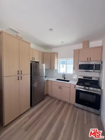 a kitchen with a refrigerator a stove top oven a sink and dishwasher