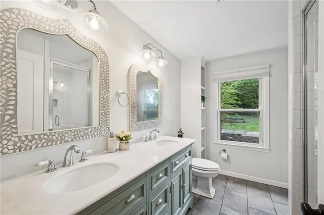 a bathroom with a granite countertop toilet a sink and a large mirror