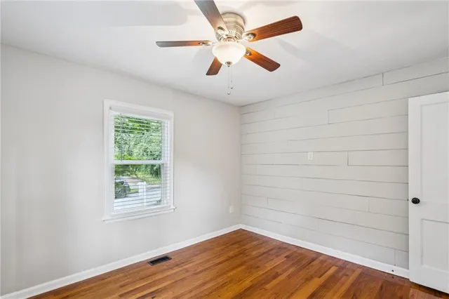 an empty room with a window and wooden floor