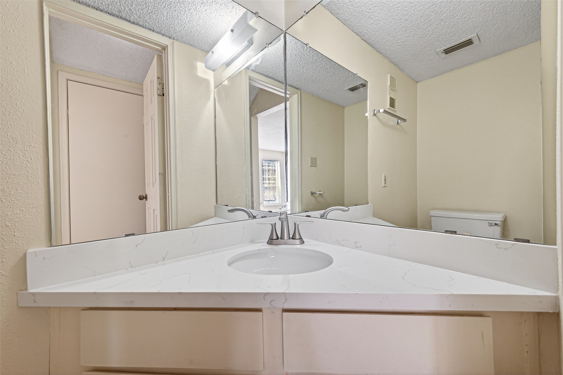 3100 Jeanetta Street, Unit 1004 Houston, TX 77063 - Photo 23 of 42 A perfectly placed half-bath featuring a space-saving corner vanity and polished fixtures for a clean, contemporary finish.