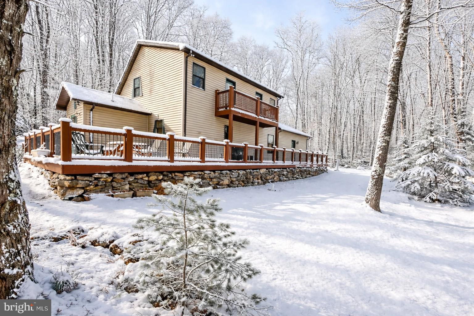 328 Stool Rock Road Oakland, MD 21550 - Photo 22 of 133 a view of a large white house with a yard covered with snow in the outdoor space