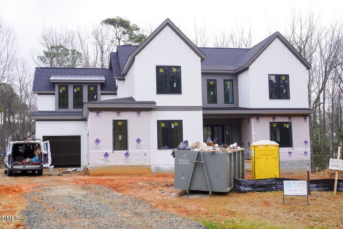 a view of a white house with large windows and a table and chairs