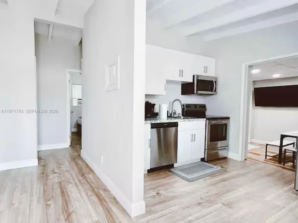 a view of a kitchen with a sink wooden floor and a living room