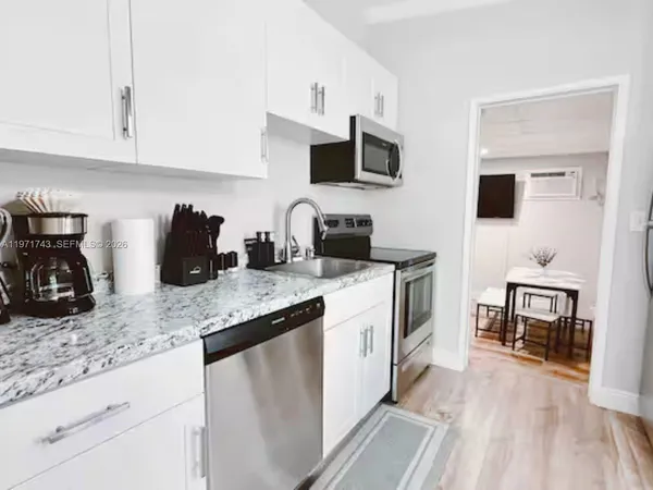 a kitchen with stainless steel appliances granite countertop a sink a stove top oven a counter space and cabinets