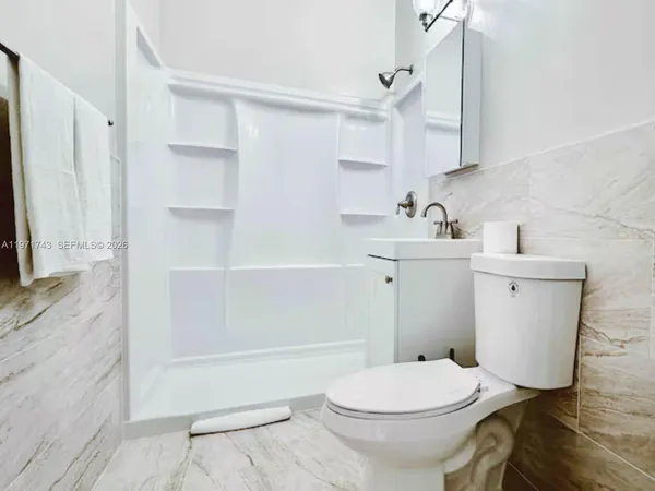 a bathroom with a sink a toilet and shower