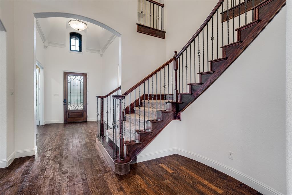 900 Jessica Lane Prosper, TX 75078 - Photo 2 of 40 Entrance embraces you with real hardwood flooring, chandelier lighting and crown molding and open feeling. The staircase makes for a grand entrance.
