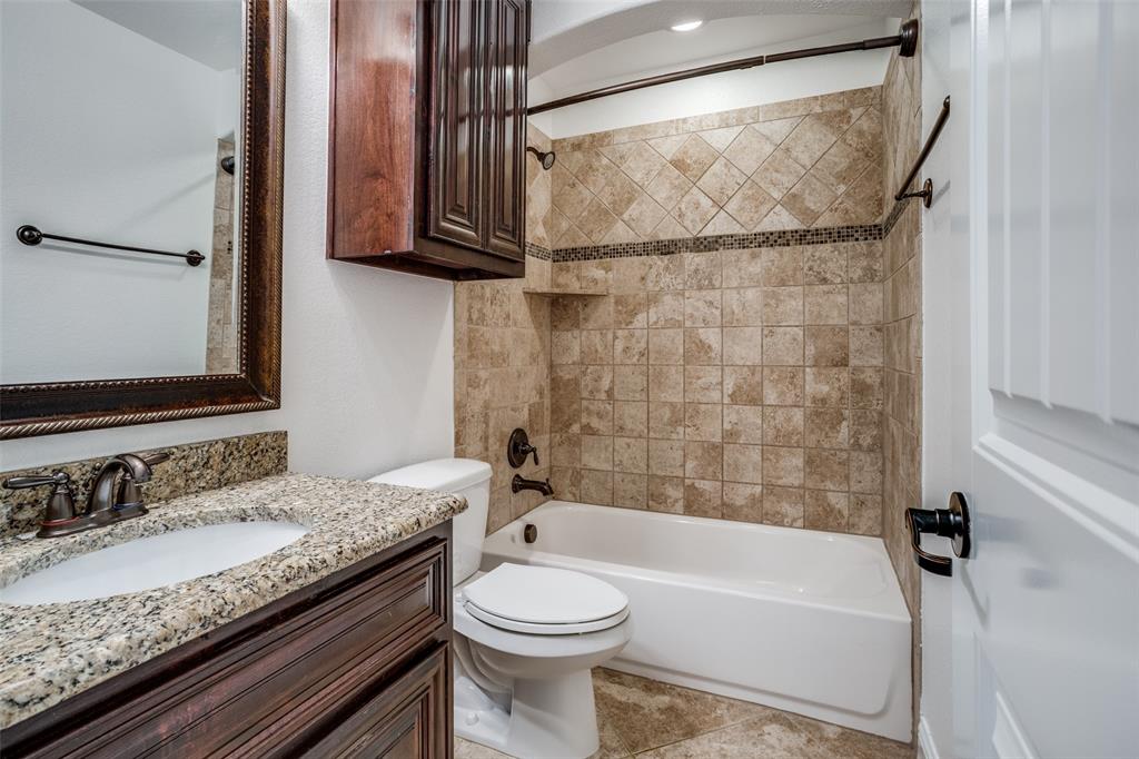 900 Jessica Lane Prosper, TX 75078 - Photo 22 of 40 a bathroom with a granite countertop bathtub sink vanity mirror and toilet