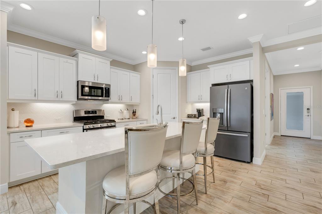 3325 Azurite Way Lakewood Ranch, FL 34211 - Photo 5 of 46 a kitchen with stainless steel appliances a refrigerator stove microwave and white cabinets