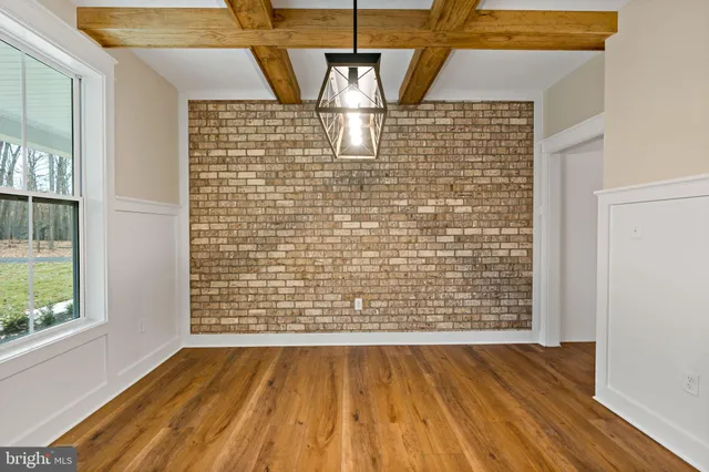 a view of empty room with wooden floor and fireplace