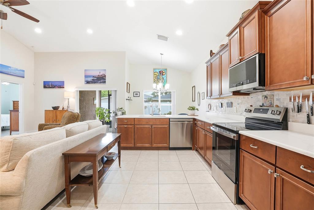 2906 West Douglas Street Tampa, FL 33607 - Photo 14 of 36 a room with stainless steel appliances kitchen island granite countertop a sink and cabinets