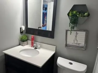 a bathroom with a toilet sink and mirror
