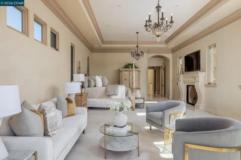 a bedroom with a large bed and a chandelier