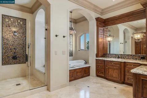 a spacious bedroom with a bed and a chandelier