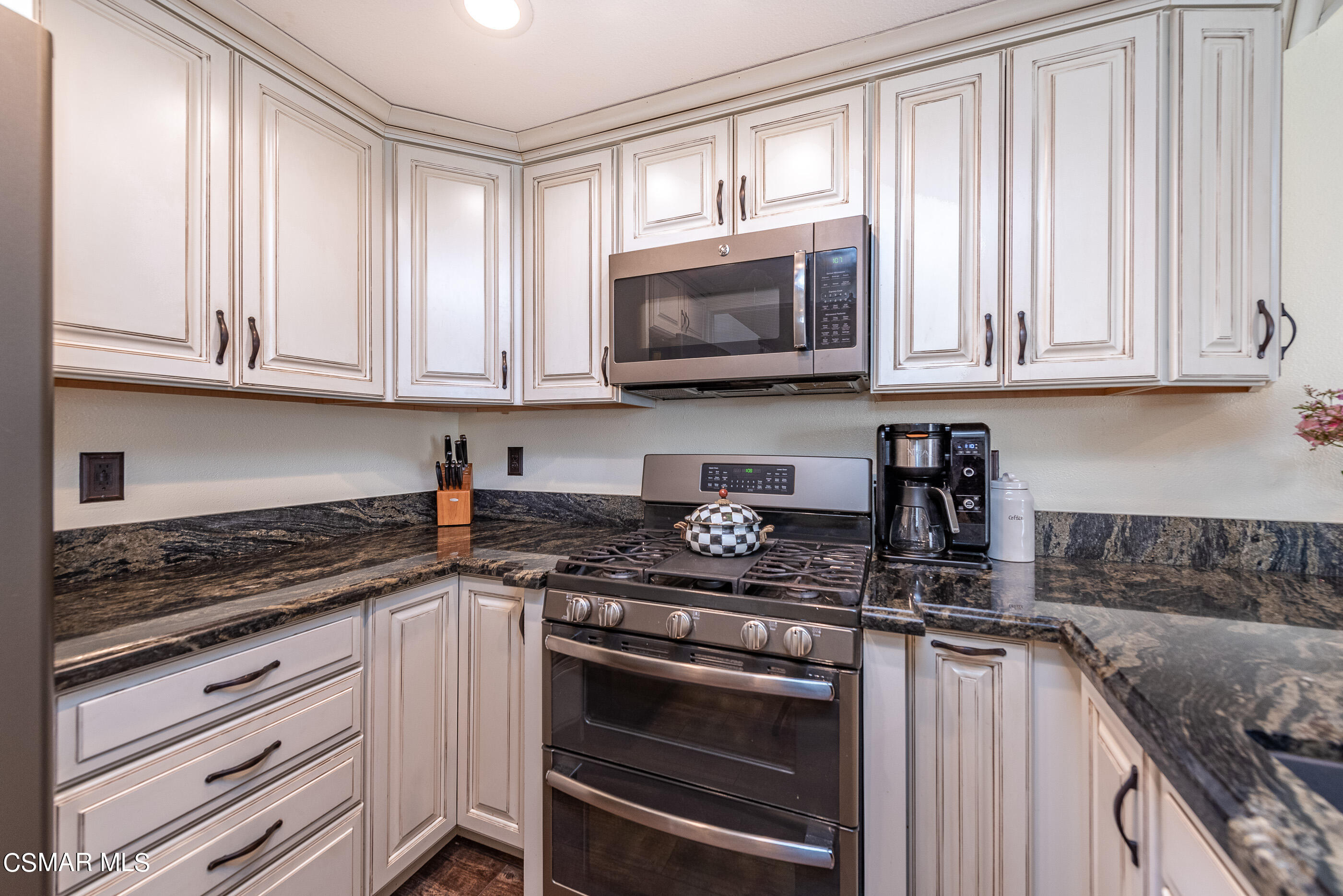 1928 Stow Street Simi Valley, CA 93063 - Photo 12 of 31 a kitchen with wooden cabinets and a stove top oven