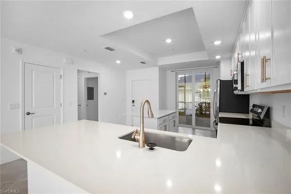 an empty room with window and a chandelier