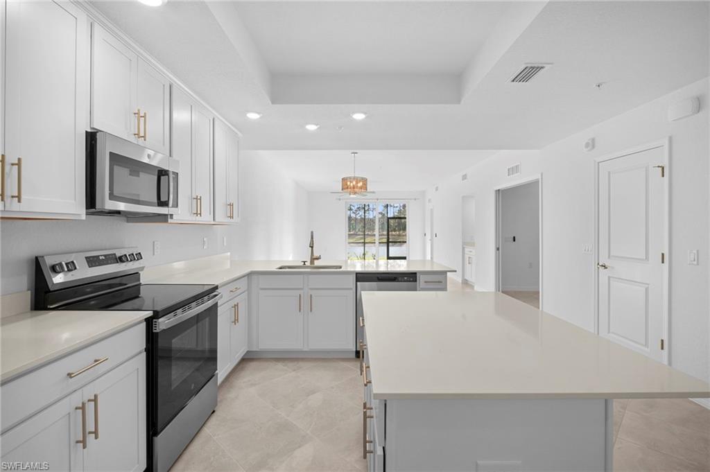15155 Bluffton Lane, Unit 517 Babcock Ranch, FL 33982 - Photo 16 of 39 a kitchen with stainless steel appliances a stove sink microwave and cabinets