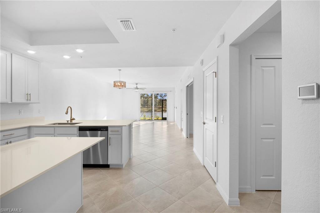 15155 Bluffton Lane, Unit 517 Babcock Ranch, FL 33982 - Photo 2 of 39 a large white kitchen with a sink and dishwasher a stove with wooden floors