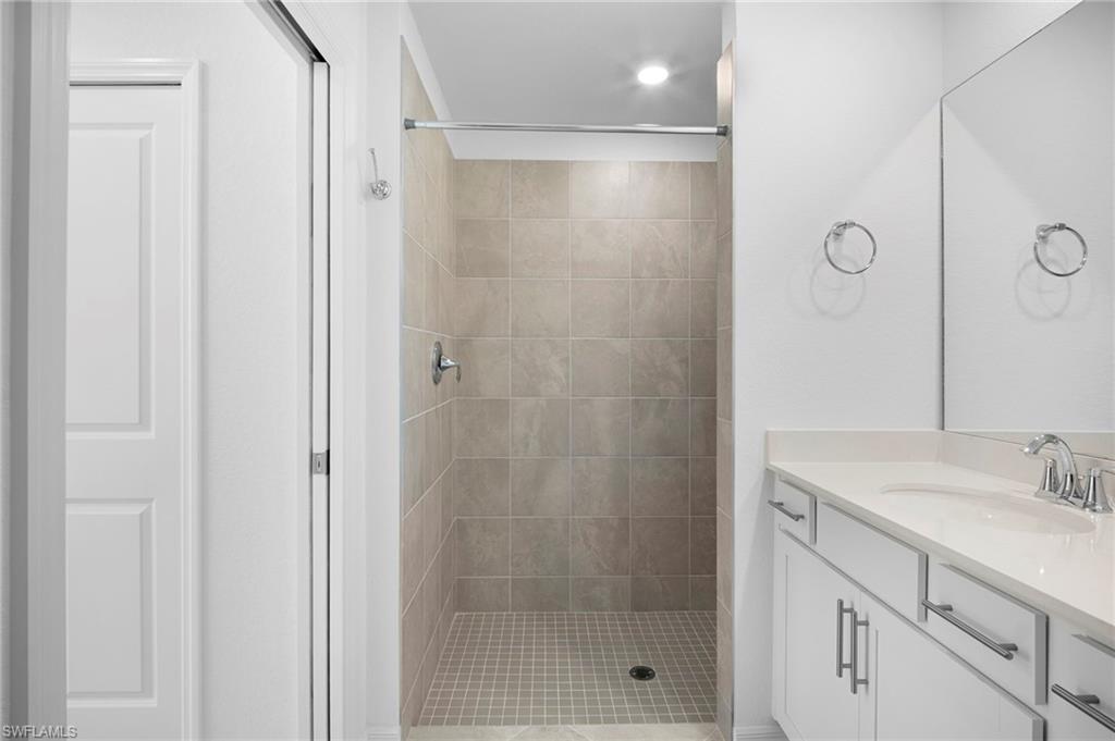 15155 Bluffton Lane, Unit 517 Babcock Ranch, FL 33982 - Photo 24 of 39 a bathroom with a shower sink vanity and mirror