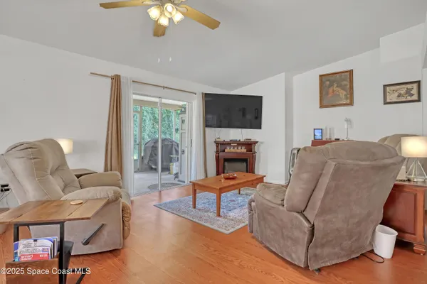 a living room with furniture a flat screen tv and a large window