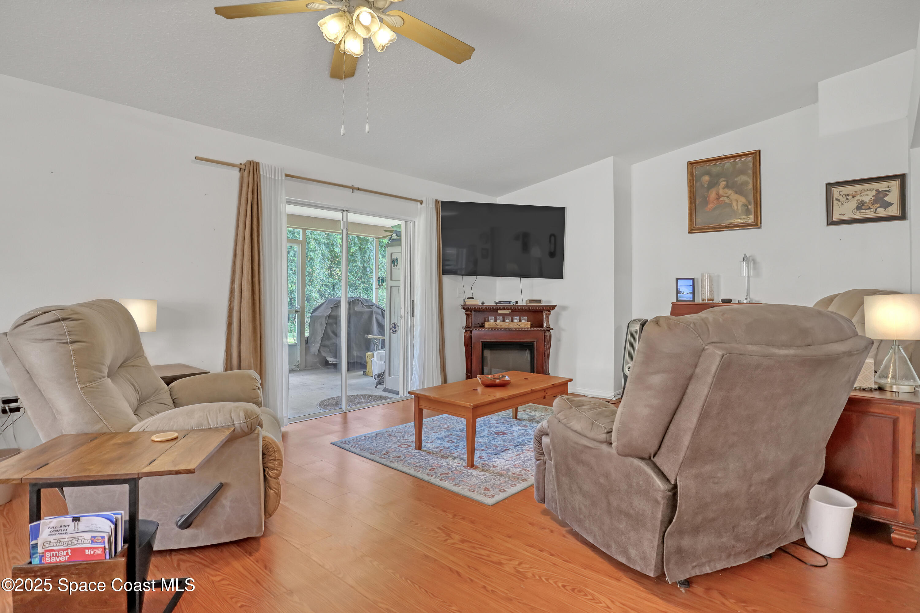 2210 Spring Creek Circle Palm Bay, FL 32905 - Photo 11 of 39 a living room with furniture a flat screen tv and a large window