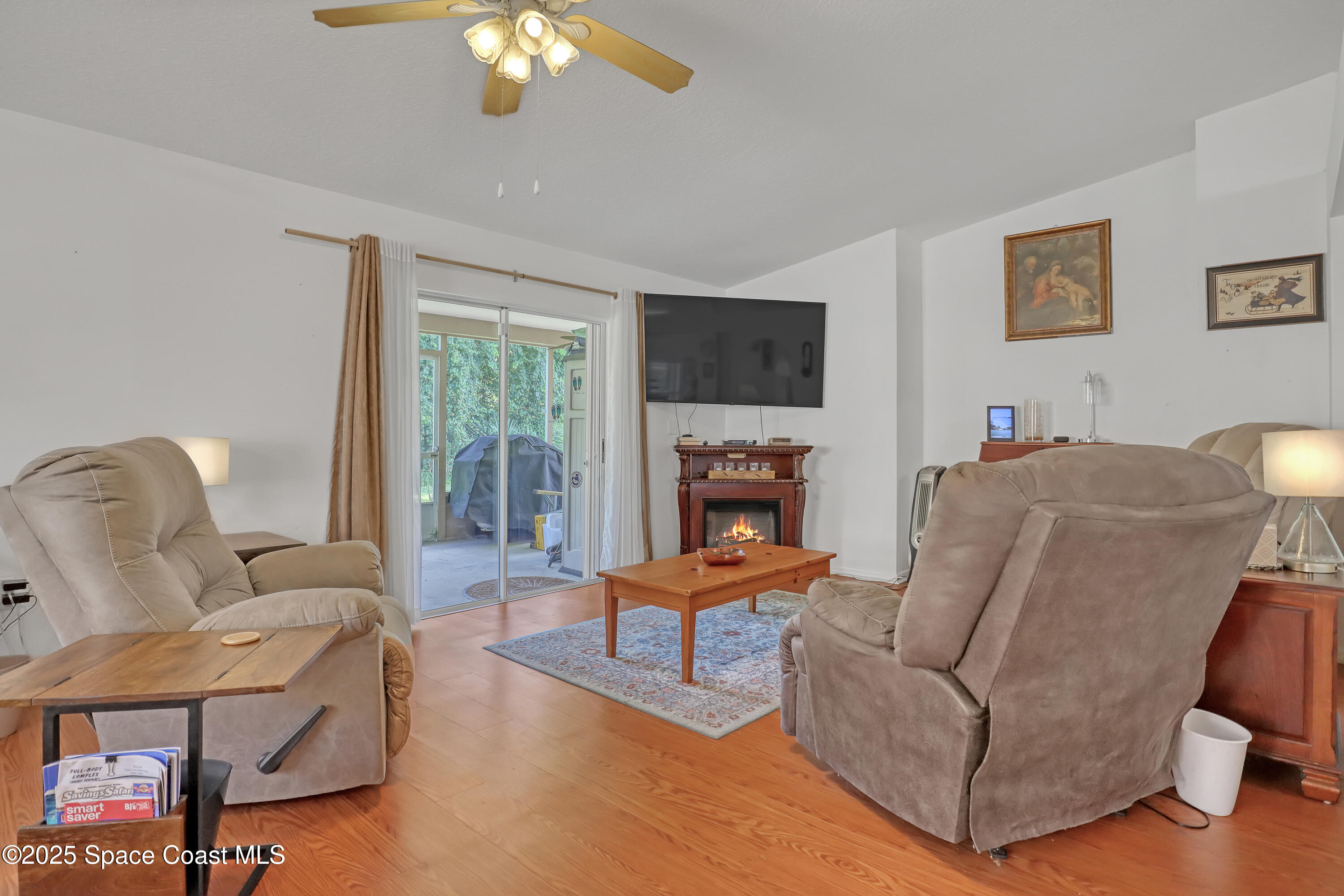 2210 Spring Creek Circle Palm Bay, FL 32905 - Photo 12 of 39 a living room with furniture a flat screen tv and a large window
