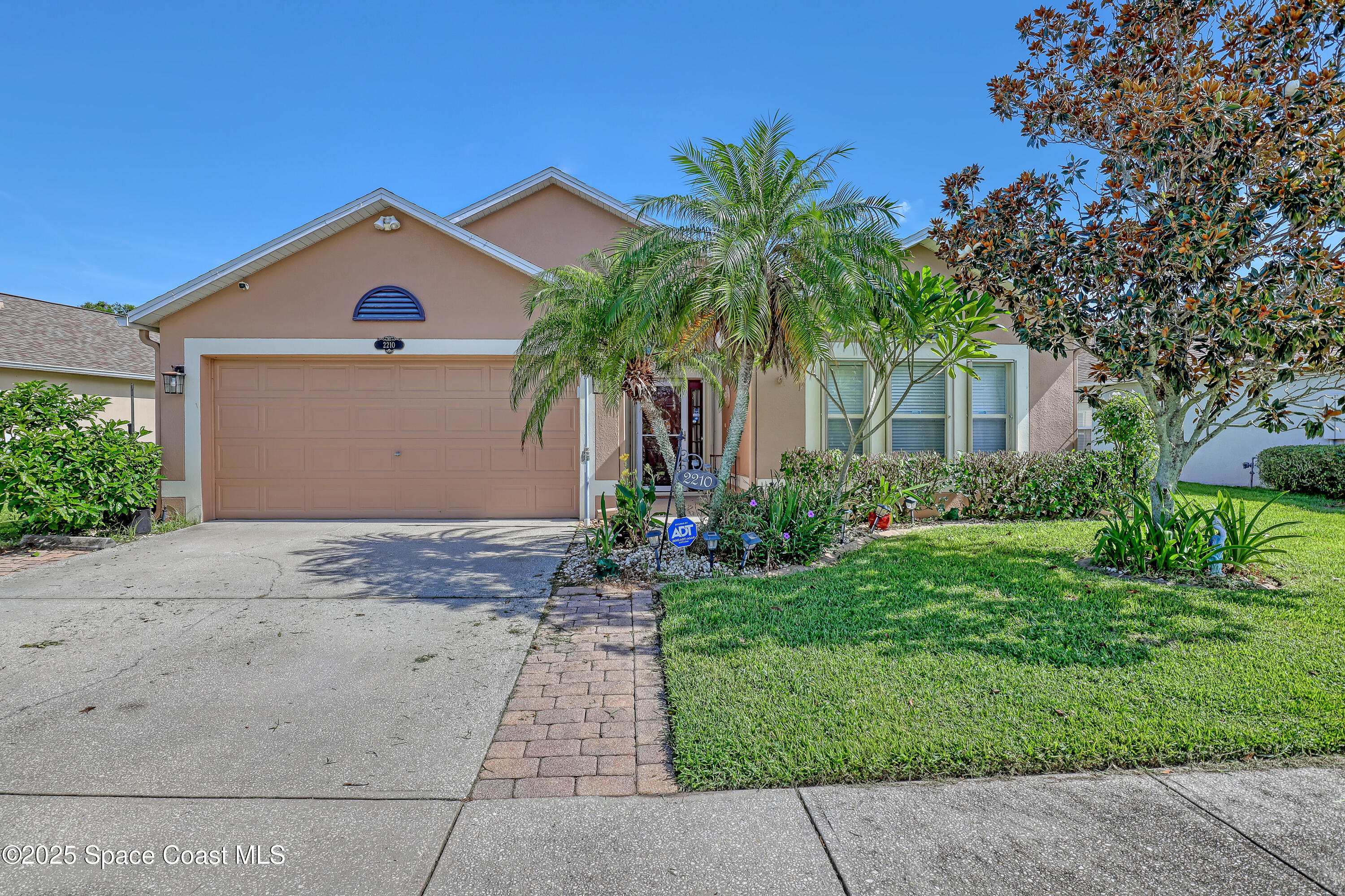 2210 Spring Creek Circle Palm Bay, FL 32905 - Photo 2 of 39 a view of a house with a yard and palm trees