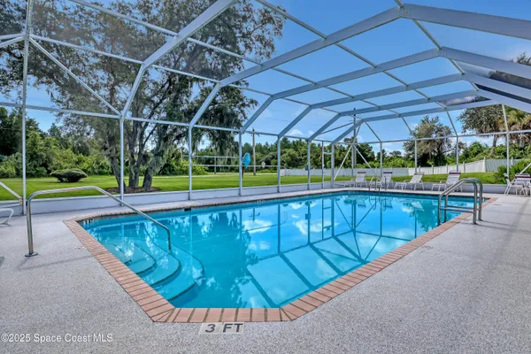 a view of a swimming pool with a patio and a yard