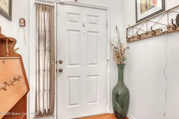 a view of a entryway with wooden floor and cabinet