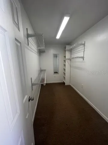 an empty room with a ceiling fan and a window