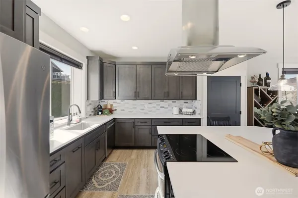 a large kitchen with a large counter top stainless steel appliances and cabinets