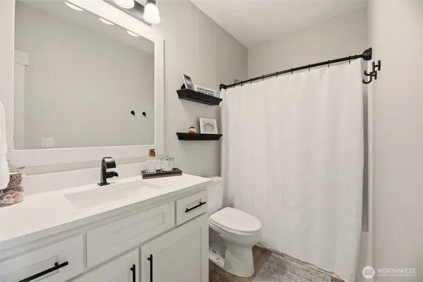 a bathroom with a sink a toilet and a mirror