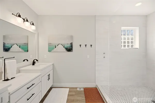 a bathroom with a sink a mirror and a shower