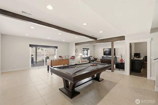 a living room with furniture pool table flat screen tv and windows