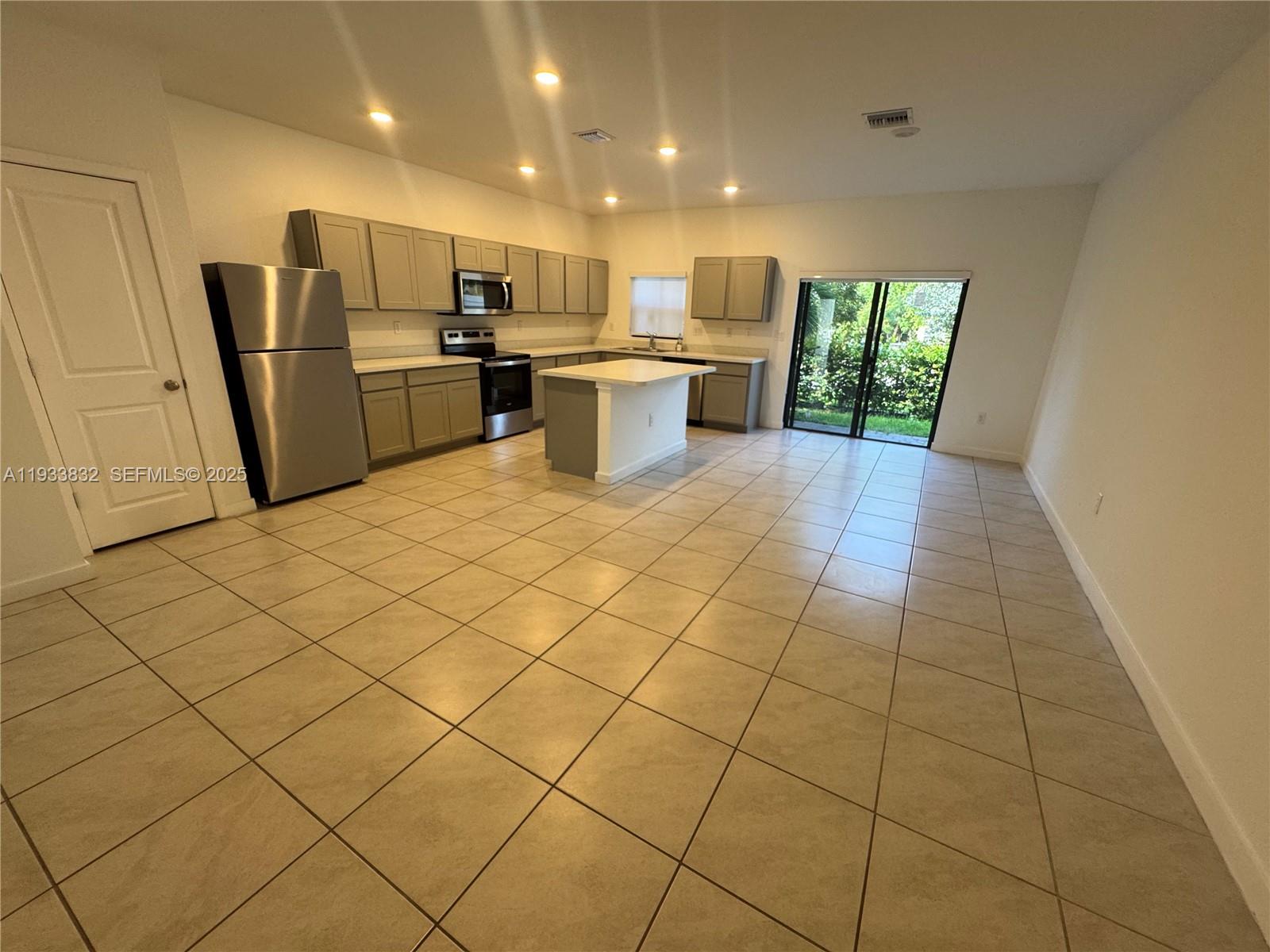 817 Northwest 3rd Way Pompano Beach, FL 33060 - Photo 5 of 13 a kitchen with stainless steel appliances a refrigerator and a stove top oven