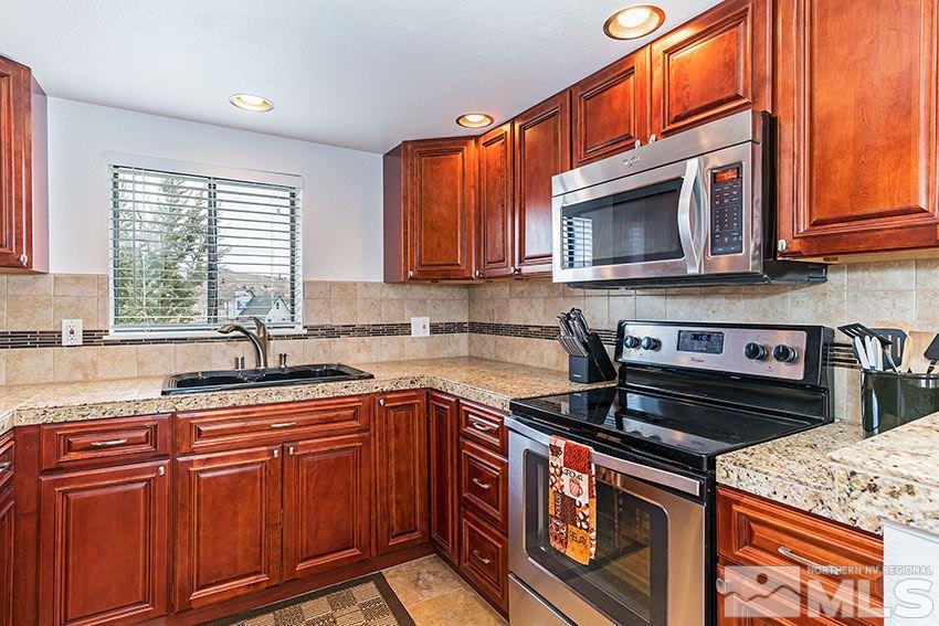 89 Vista Rafael Parkway Reno, NV 89503 - Photo 1 of 16 a kitchen with stainless steel appliances granite countertop a stove top oven a sink dishwasher and cabinets with wooden floor