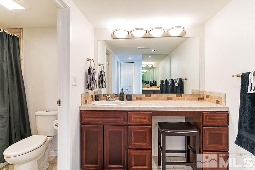 89 Vista Rafael Parkway Reno, NV 89503 - Photo 10 of 16 a spacious bathroom with a granite countertop sink a toilet and a mirror