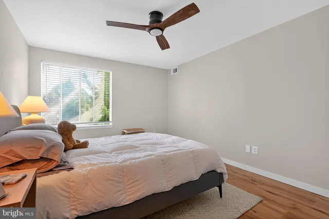 a bedroom with a bed a window and dresser