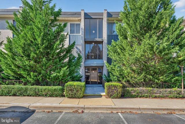 a car parked in front of a brick house with large windows
