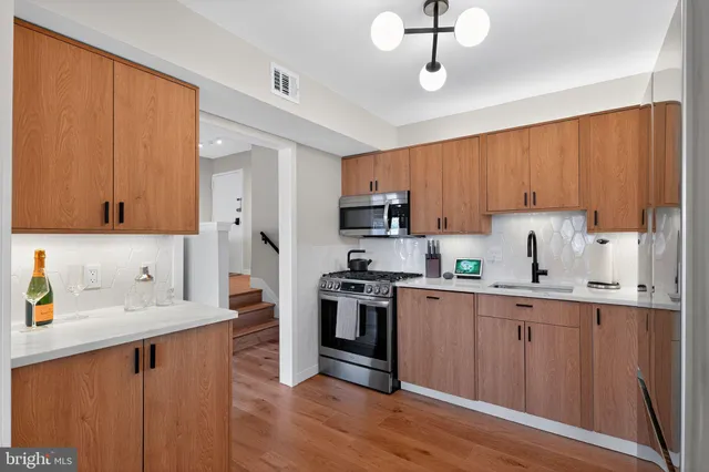 a kitchen with stainless steel appliances granite countertop a sink stove and refrigerator