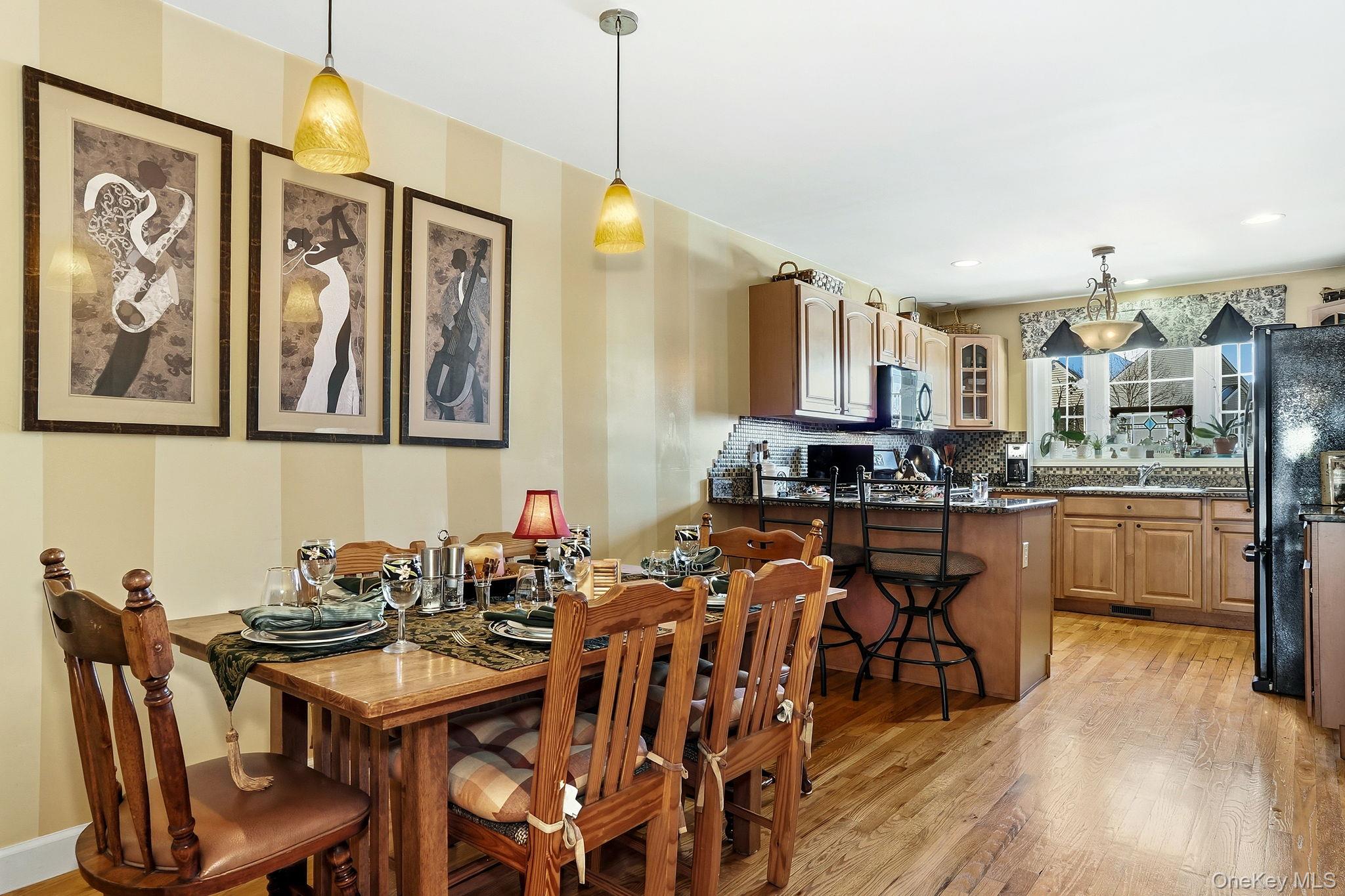 1604 Pondview Loop Wappingers Falls, NY 12590 - Photo 11 of 37 a kitchen with stainless steel appliances a table chairs and a refrigerator