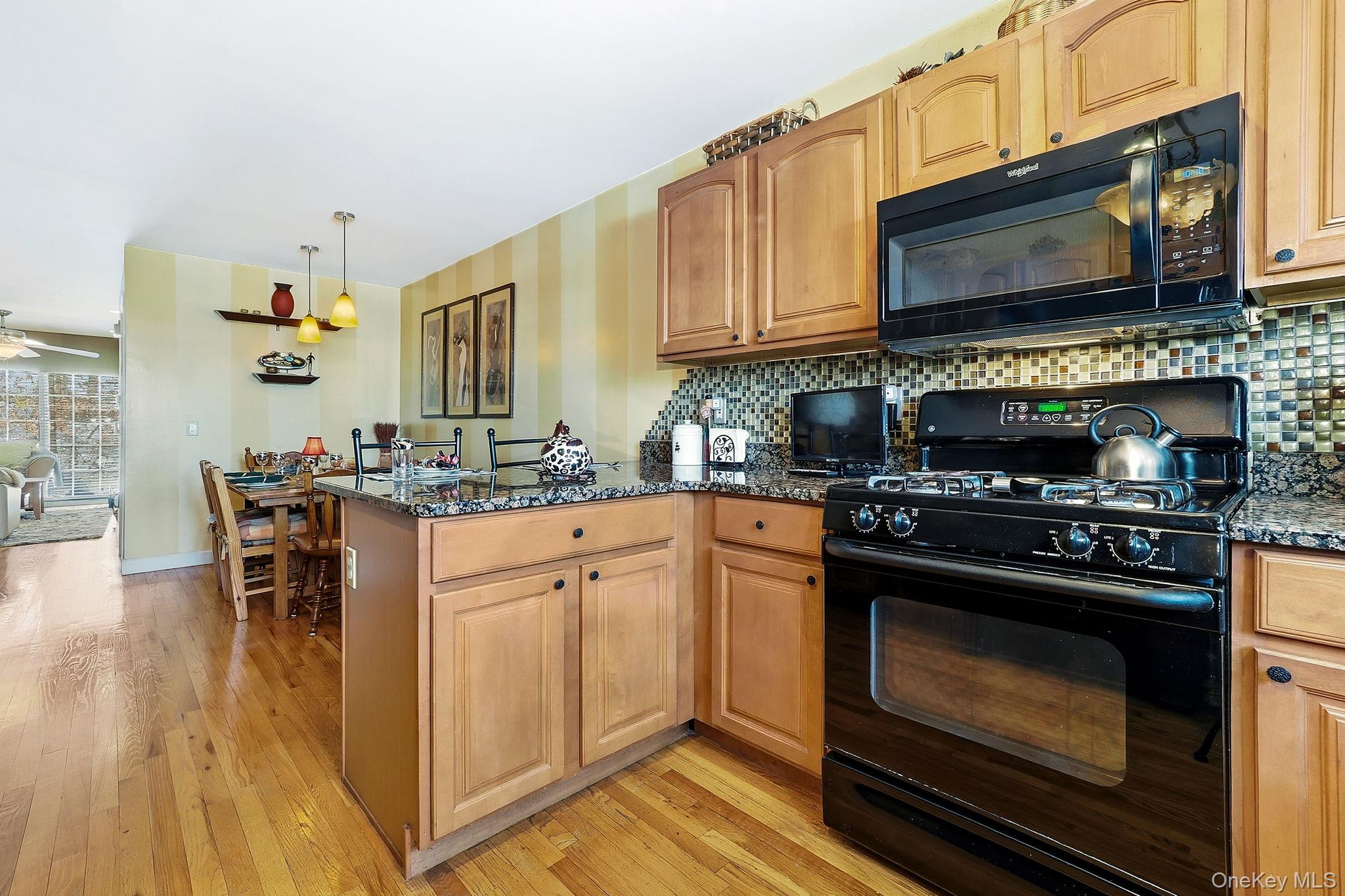 1604 Pondview Loop Wappingers Falls, NY 12590 - Photo 16 of 37 a kitchen with stainless steel appliances granite countertop a stove a sink and a microwave