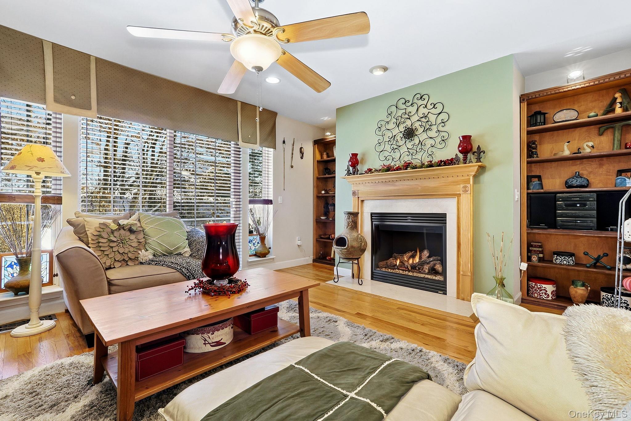 1604 Pondview Loop Wappingers Falls, NY 12590 - Photo 8 of 37 a living room with furniture a flat screen tv and a fireplace