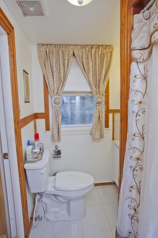 267 Shawmut Street Springfield, MA 01108 - Photo 22 of 30 a white toilet sitting next to a bathroom sink and a shower curtain
