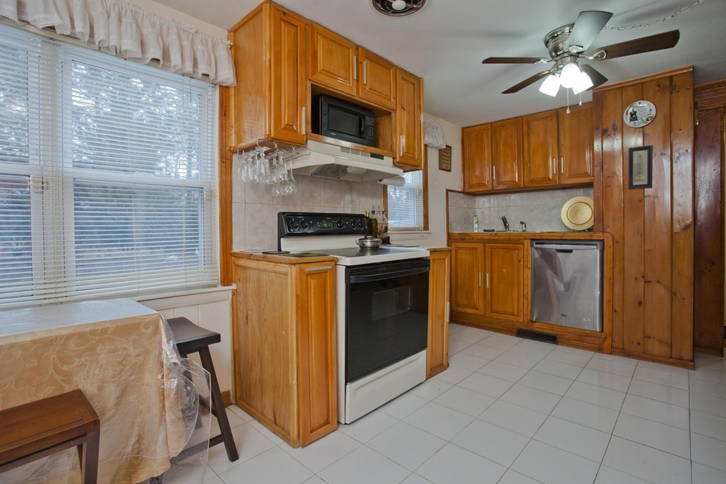 267 Shawmut Street Springfield, MA 01108 - Photo 7 of 30 a kitchen with stainless steel appliances granite countertop a stove top oven a sink a dining table and chairs