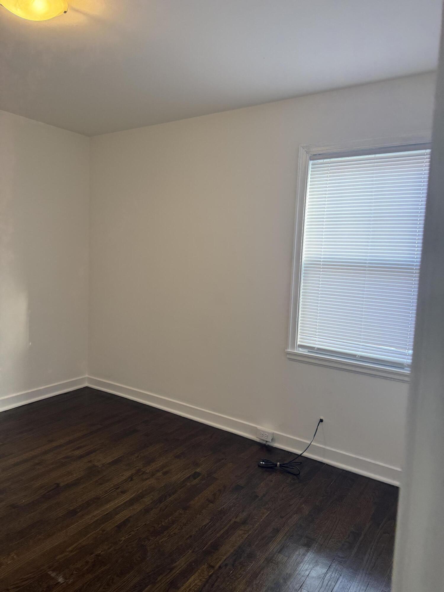 541 Chase Street Gary, IN 46404 - Photo 6 of 13 a view of an empty room with wooden floor and a window